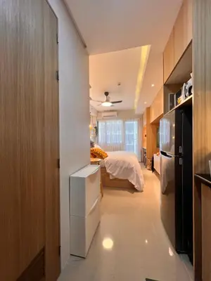 a small bedroom with a bed and a refrigerator at Condo Living at Shore with Parking in Manila