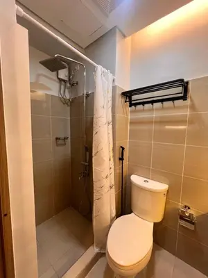 a bathroom with a toilet and a shower at Condo Living at Shore with Parking in Manila