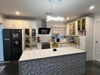 a kitchen with white cabinets and a black refrigerator at Elegant 5BR Home Near BGC in Manila