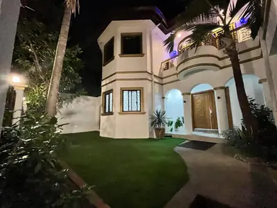 a large house with a green yard at night at Elegant 5BR Home Near BGC in Manila