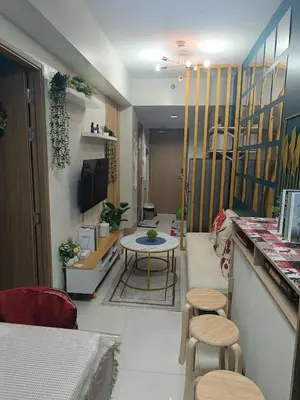a living room with a table and stools in a room at SkyShore Suites in Manila