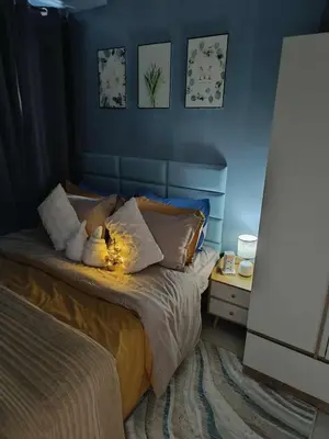 a bedroom with a bed with lights on it at SkyShore Suites in Manila