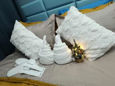 a bed with two white towels and a christmas ornament at SkyShore Suites in Manila