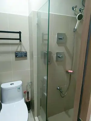 a bathroom with a glass shower with a toilet at SkyShore Suites in Manila