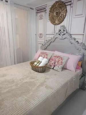 a bedroom with a bed with a basket of towels at Azure Urban Resort Residences - St Tropez Tower in Manila