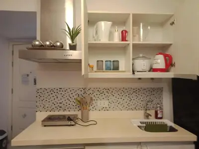 a kitchen with white cabinets and a sink at Azure Urban Resort Residences - St Tropez Tower in Manila