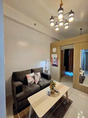 a living room with a couch and a table at Maison dela Mer SMDC Breeze Residences Pasay in Manila