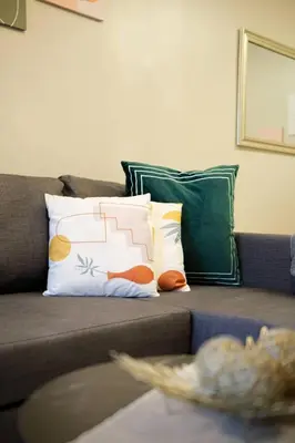 a couch with several pillows on top of it at Luxurious Maison at 81 Newport near Terminal 3 Airport in Manila