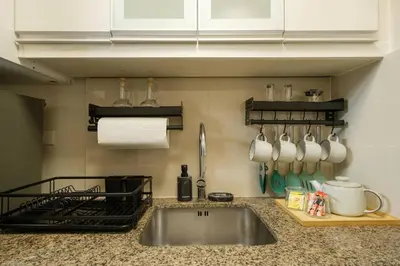 a kitchen counter with a sink and a stove at Luxurious Maison at 81 Newport near Terminal 3 Airport in Manila