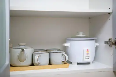 a shelf with three tea pots and a coffee maker at Luxurious Maison at 81 Newport near Terminal 3 Airport in Manila