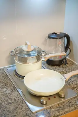 a stove top with pots and pans on a counter at Luxurious Maison at 81 Newport near Terminal 3 Airport in Manila
