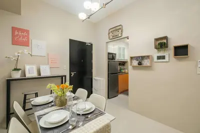 a dining room with a table and chairs and a kitchen at Luxurious Maison at 81 Newport near Terminal 3 Airport in Manila