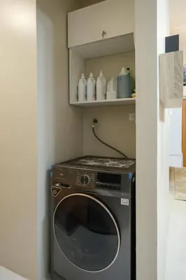 a washer and dryer in a small kitchen at Luxurious Maison at 81 Newport near Terminal 3 Airport in Manila