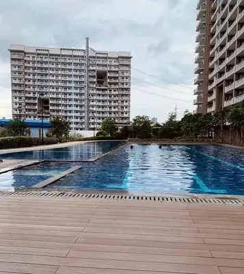 a large swimming pool in front of a large building at Cozy 1BR Staycation at Satori Residences, Pasig in Manila