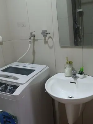 a white bathroom with a sink and a stove at Pasay Staycation manila bay view in Manila