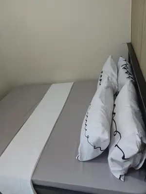 two white pillows sitting on top of a bed at Pasay Staycation manila bay view in Manila