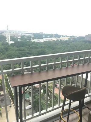 a chair sitting on a balcony with a view at Pasay Staycation manila bay view in Manila