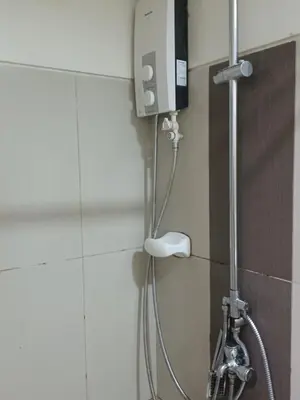 a shower in a bathroom with a shower head at Pasay Staycation manila bay view in Manila