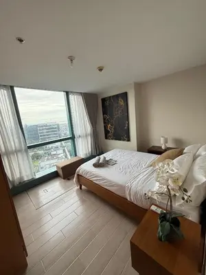 a bedroom with a large bed and large windows at One Uptown Residence, BGC - Standard 2 Bedroom Unit in Manila