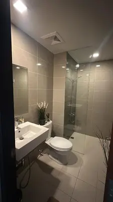 a bathroom with a toilet and a sink and a shower at One Uptown Residence, BGC - Standard 2 Bedroom Unit in Manila