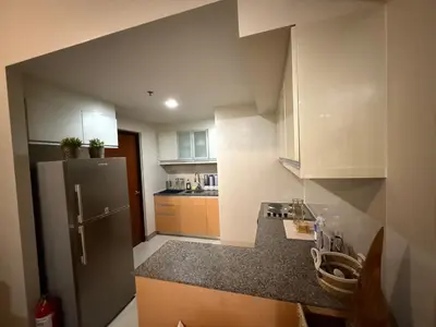 a small kitchen with a stainless steel refrigerator at One Uptown Residence, BGC - Standard 2 Bedroom Unit in Manila