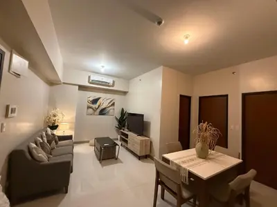a living room with a couch and a table at One Uptown Residence, BGC - Standard 2 Bedroom Unit in Manila