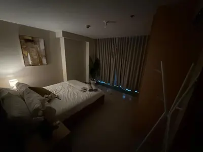 a bedroom with a bed and a window with lights at One Uptown Residence, BGC - Standard 2 Bedroom Unit in Manila