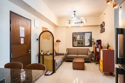 a living room with a couch and a table at One Uptown 2 Bedroom with 3 Beds Uptown Mall View in Manila