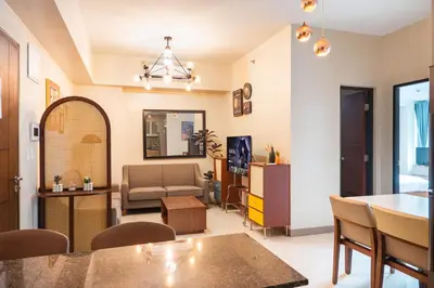 a living room with a couch and a table at One Uptown 2 Bedroom with 3 Beds Uptown Mall View in Manila