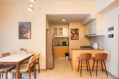 a kitchen and dining room with a table and chairs at One Uptown 2 Bedroom with 3 Beds Uptown Mall View in Manila