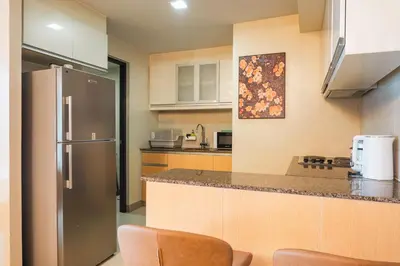 a kitchen with a refrigerator and a counter top at One Uptown 2 Bedroom with 3 Beds Uptown Mall View in Manila