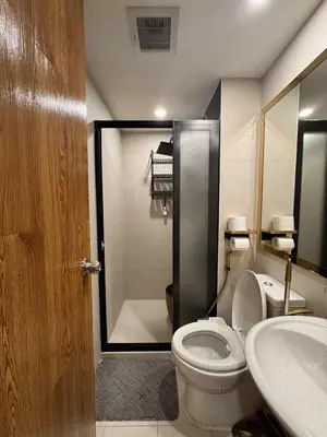 a bathroom with a toilet and a sink and a shower at Horiyama staycation azure in Manila