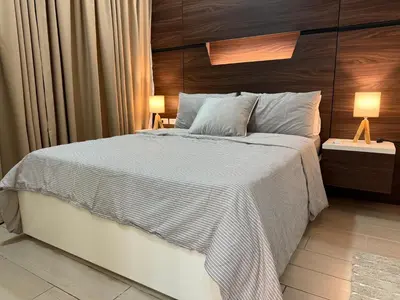 a bedroom with a large bed with a wooden headboard at Luxury 2BR w Balcony BGC Taguig near Venice Mall in Manila