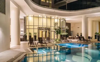 a lobby with a pool and chairs and a building at Luxury 2BR w Balcony BGC Taguig near Venice Mall in Manila