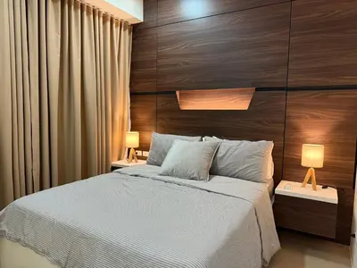 a bedroom with a large bed with a wooden headboard at Luxury 2BR w Balcony BGC Taguig near Venice Mall in Manila