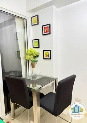 a dining room table with chairs and a vase of flowers at Azure Urban Resort Residences by Amóre Suites in Manila