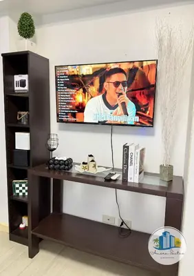 a television on a wall in a living room at Azure Urban Resort Residences by Amóre Suites in Manila