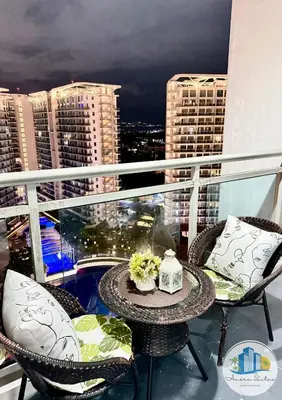 a balcony with a table and chairs and a view of a city at Azure Urban Resort Residences by Amóre Suites in Manila