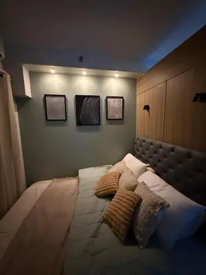 a bedroom with a bed with three pillows on it at The Nook in Pasay in Manila