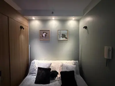 a bedroom with a bed with white sheets and pillows at The Nook in Pasay in Manila