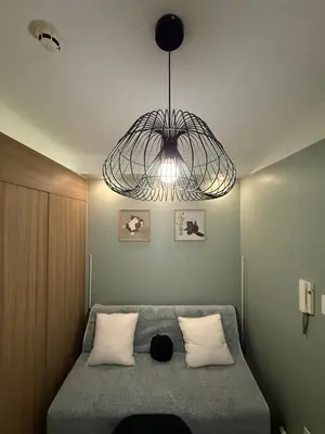 a bedroom with a bed with a black cat laying on it at The Nook in Pasay in Manila