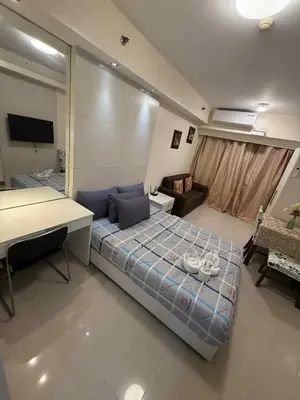 a bedroom with a bed and a table and a couch at Sea Residences Condotel With Balcony, by Rose in Manila
