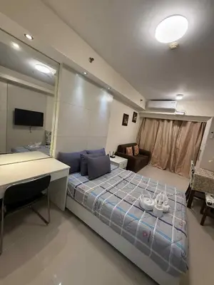 a bedroom with a bed and a desk in it at Sea Residences Condotel With Balcony, by Rose in Manila