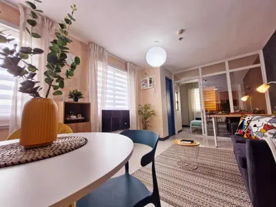 a living room with a table and chairs at Vibrant Spacious Condo near SM East NU Medical City in Manila