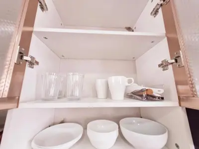 a white cabinet with two toilets and a sink at Vibrant Spacious Condo near SM East NU Medical City in Manila