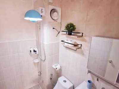 a bathroom with a white toilet and a blue lamp at Vibrant Spacious Condo near SM East NU Medical City in Manila
