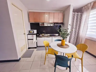 a small kitchen with a white table and chairs at Vibrant Spacious Condo near SM East NU Medical City in Manila