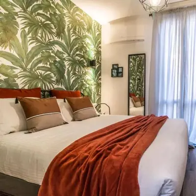 a bedroom with a large bed with a tropical wallpaper at Sunvalley B&b in Manila