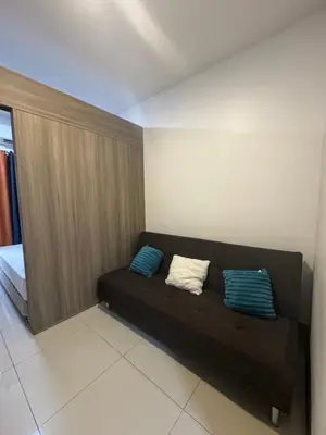 a black couch with two pillows in a room at FAME RESIDENCES CONDO-TEL Near EDSA Shang in Manila