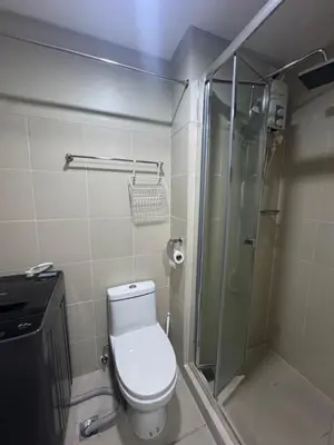 a bathroom with a toilet and a glass shower at FAME RESIDENCES CONDO-TEL Near EDSA Shang in Manila